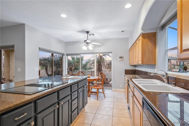 kitchen featuring dark stone countertops, visible vents, a sink, and black appliances