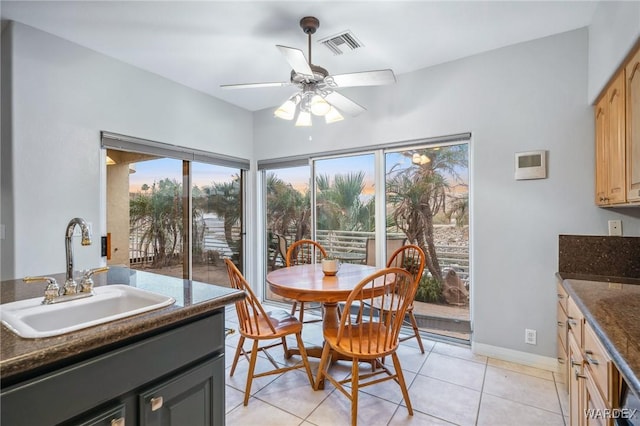 dining area with light tile patterned floors, baseboards, visible vents, and ceiling fan