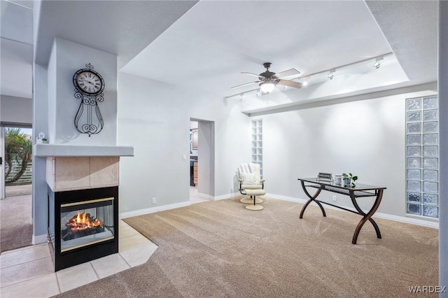 sitting room with ceiling fan, light colored carpet, a fireplace, baseboards, and track lighting