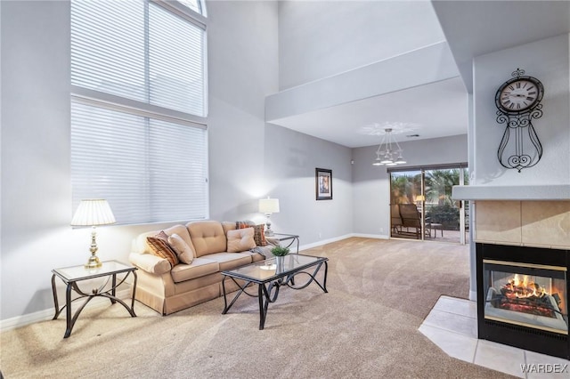 living room with baseboards, light colored carpet, a fireplace, and a high ceiling