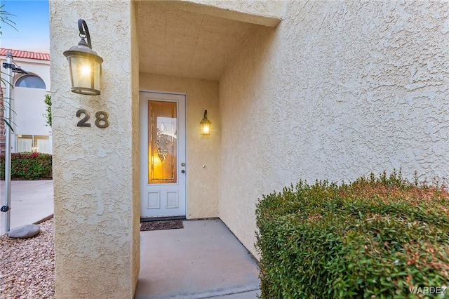 view of exterior entry with stucco siding