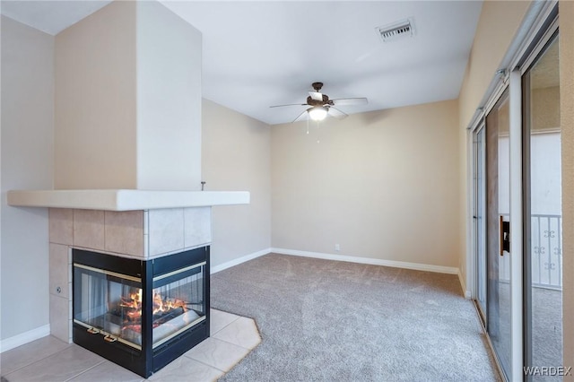 unfurnished living room featuring light colored carpet, a tile fireplace, visible vents, and baseboards