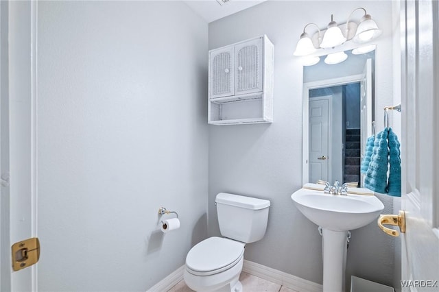 bathroom with baseboards and toilet