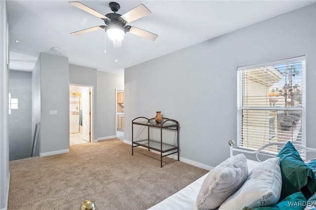 bedroom featuring light carpet, a ceiling fan, baseboards, and connected bathroom