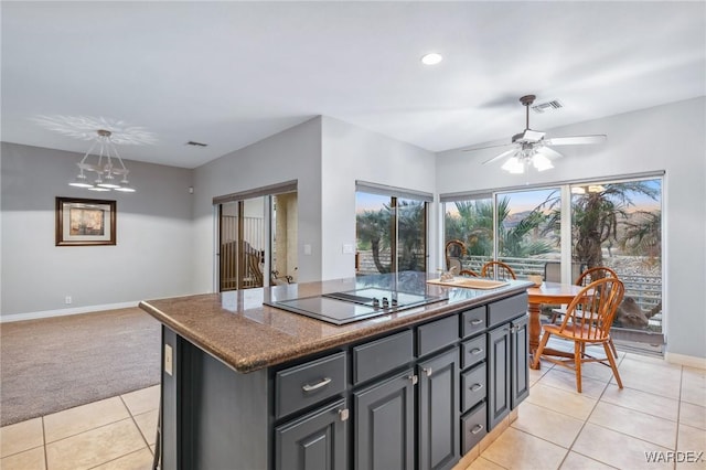 kitchen with light tile patterned floors, a center island with sink, visible vents, black electric cooktop, and a sink