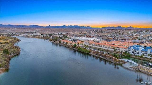 aerial view at dusk featuring a residential view and a water and mountain view