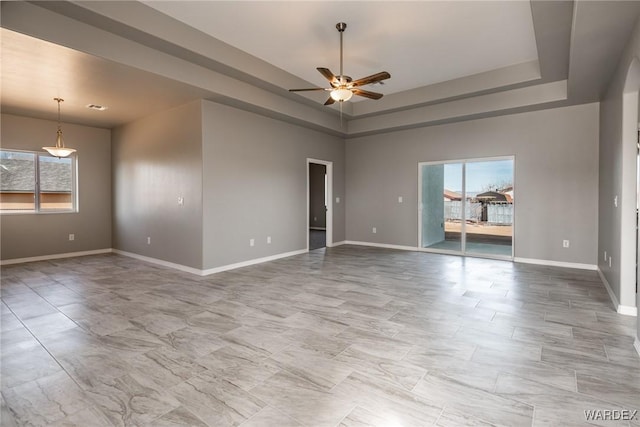 spare room with a ceiling fan, baseboards, and a wealth of natural light