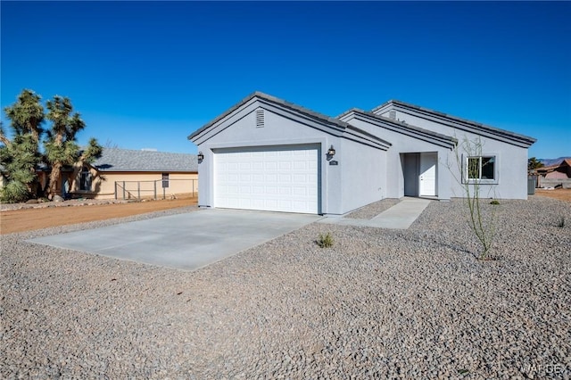 ranch-style house featuring driveway, an attached garage, and stucco siding