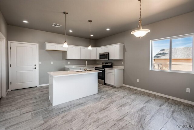 kitchen featuring a center island with sink, white cabinets, stainless steel appliances, light countertops, and a sink