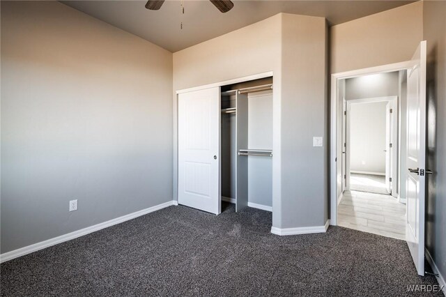 unfurnished bedroom featuring a closet, dark carpet, and baseboards