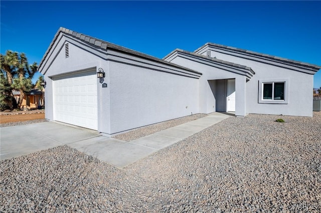 ranch-style home with a garage, driveway, and stucco siding