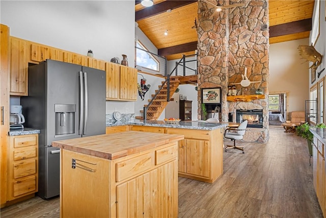 18723 E Knight Creek Rd, Kingman, AZ 86401 - kitchen featuring stainless steel fridge, high vaulted ceiling, wood counters, a kitchen island, and a stone fireplace