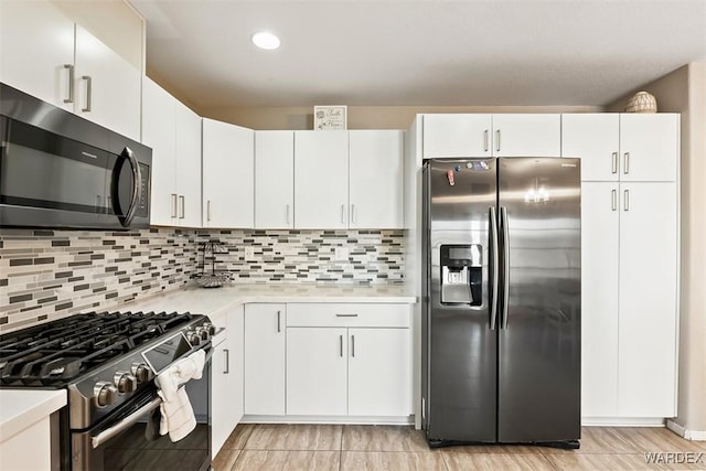 kitchen with white cabinets, stainless steel appliances, light countertops, backsplash, and recessed lighting