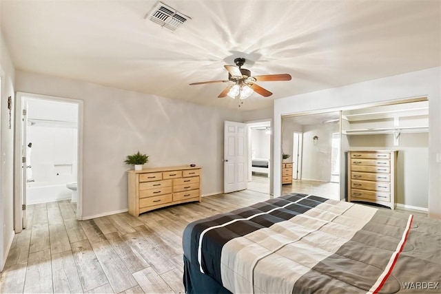 bedroom featuring ensuite bathroom, light wood-type flooring, visible vents, and baseboards