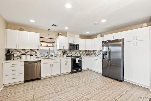 kitchen featuring stainless steel appliances, light countertops, a sink, and visible vents