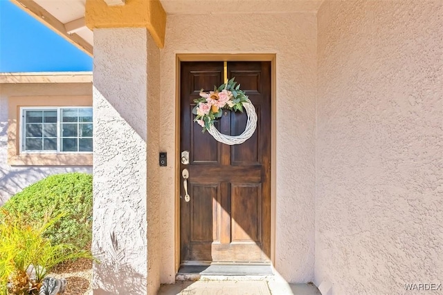 view of exterior entry with stucco siding