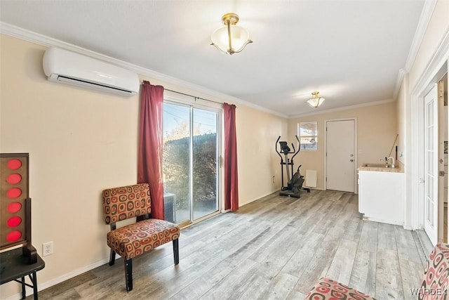 sitting room featuring baseboards, a wall mounted AC, light wood-type flooring, and crown molding