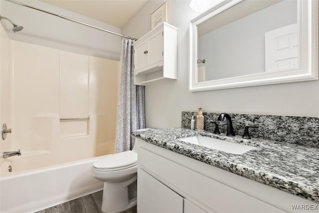 full bath featuring toilet, shower / bath combo with shower curtain, wood finished floors, and vanity