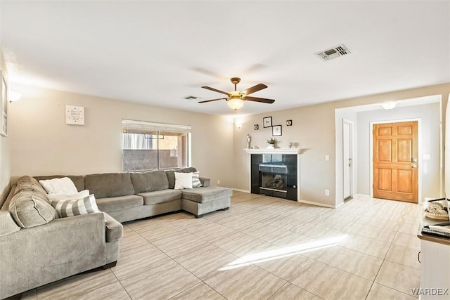 living area with a ceiling fan, visible vents, a fireplace, and baseboards