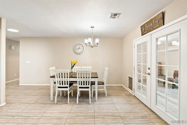 dining area with baseboards, visible vents, a notable chandelier, and french doors