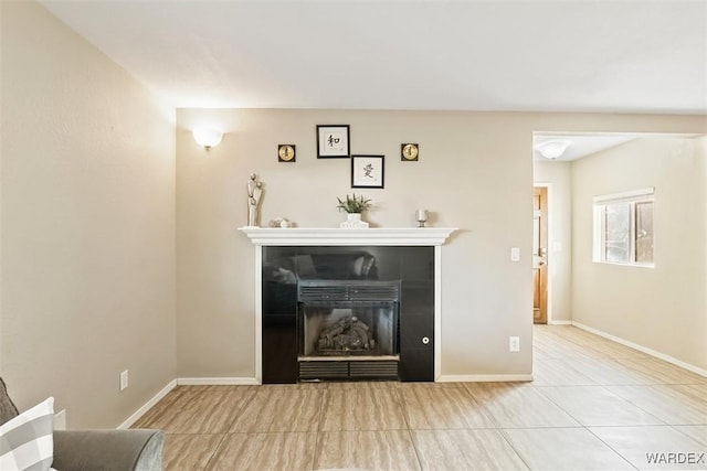 unfurnished living room featuring tile patterned flooring, a fireplace, and baseboards