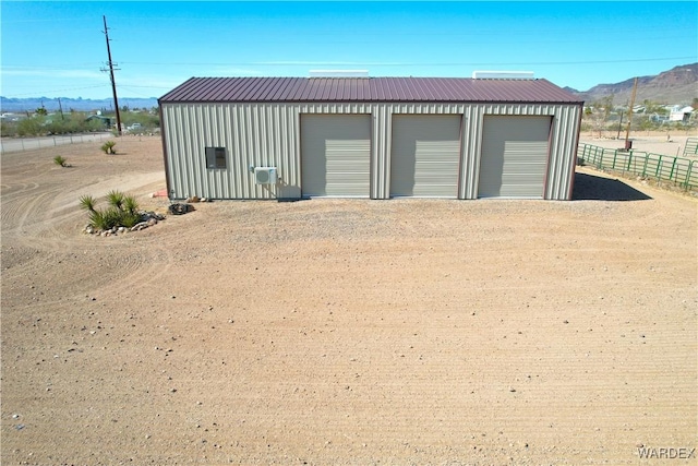 detached garage featuring fence