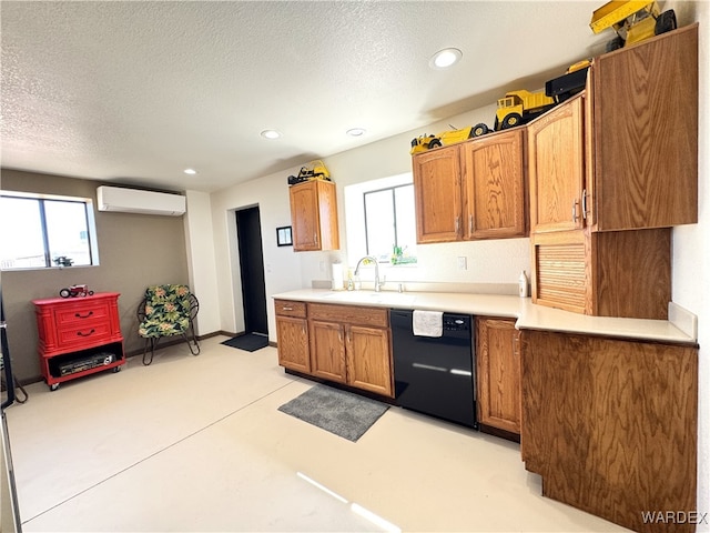 kitchen featuring a sink, an AC wall unit, light countertops, dishwasher, and a wealth of natural light