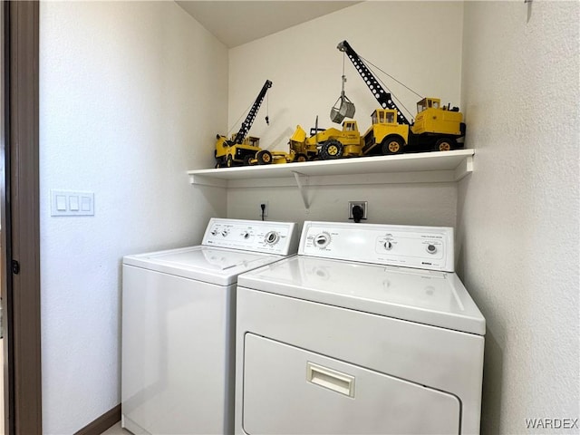 laundry room featuring separate washer and dryer, laundry area, and a textured wall