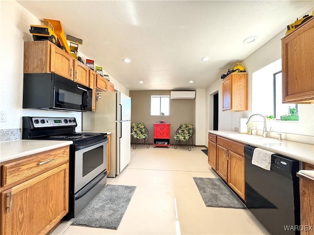 kitchen with black appliances, an AC wall unit, light countertops, and a sink