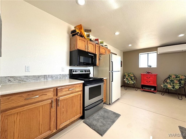 kitchen featuring a wall mounted air conditioner, stainless steel range with electric stovetop, a textured ceiling, freestanding refrigerator, and black microwave