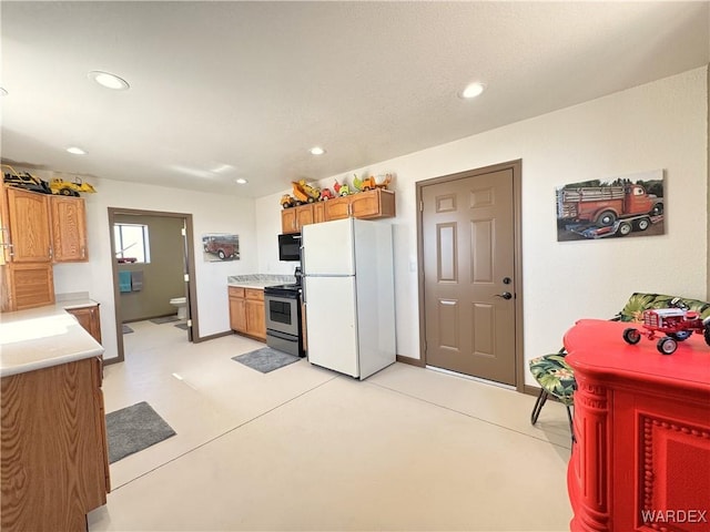 kitchen featuring black microwave, light countertops, recessed lighting, freestanding refrigerator, and electric range