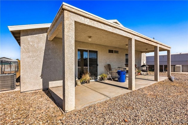 rear view of property with central air condition unit, a patio area, fence, and stucco siding