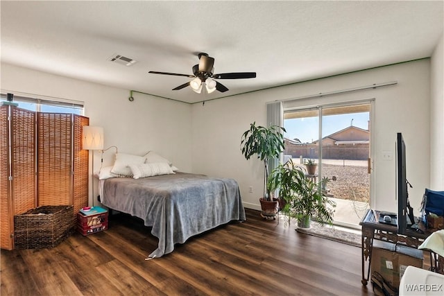 bedroom featuring dark wood-type flooring, multiple windows, visible vents, and access to exterior