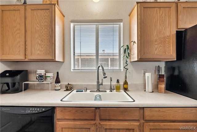 kitchen featuring light countertops, dishwasher, and a sink