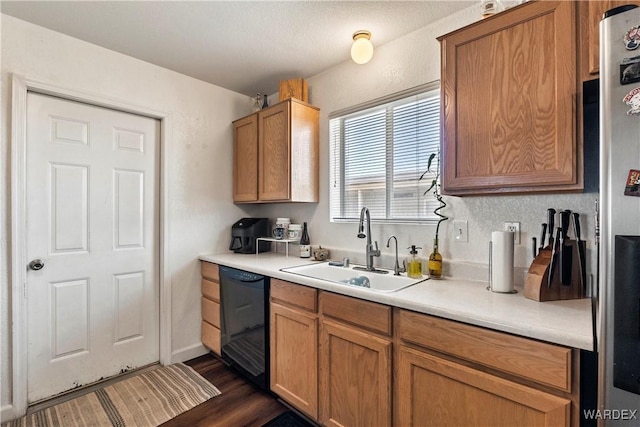 kitchen with brown cabinets, black dishwasher, light countertops, and a sink