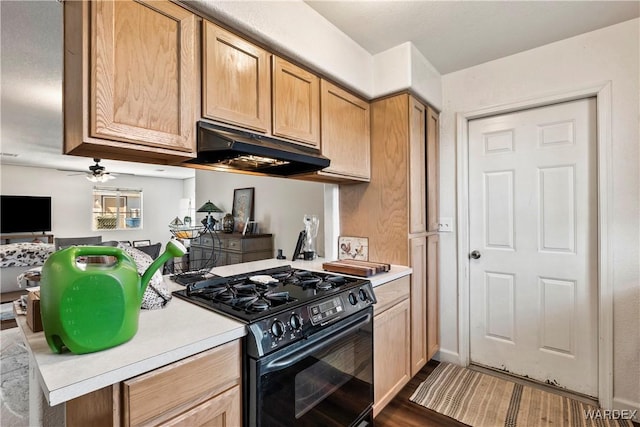 kitchen with light countertops, black range with gas stovetop, open floor plan, wood finished floors, and under cabinet range hood