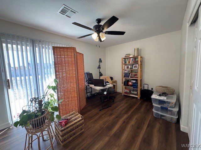 office space with dark wood-type flooring, plenty of natural light, and visible vents