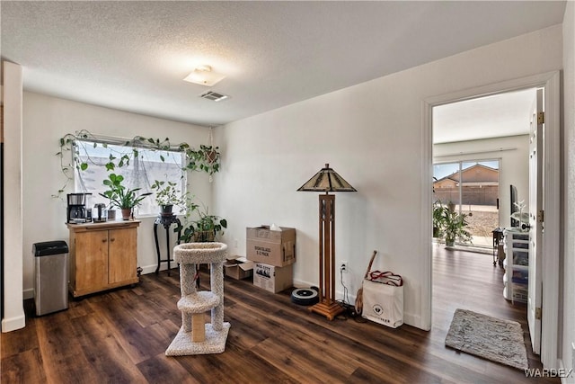 dining space with dark wood-style floors, visible vents, and a textured ceiling