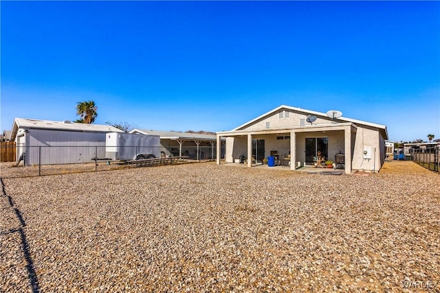 rear view of house featuring a patio and fence