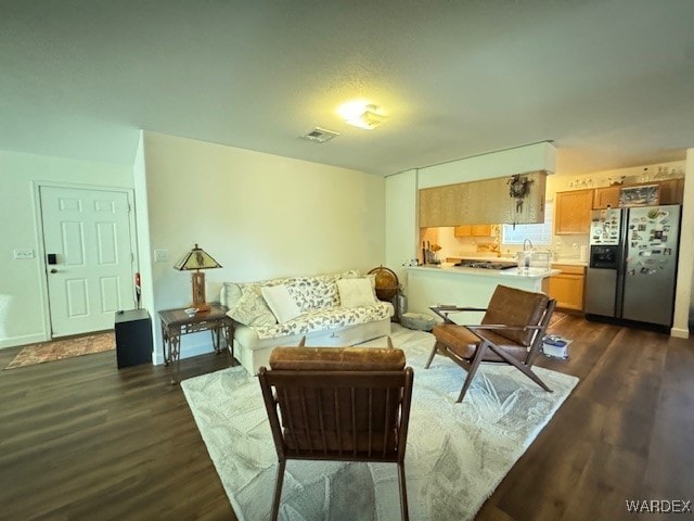 living area featuring dark wood-type flooring and visible vents