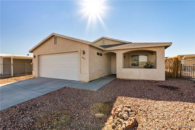 single story home with concrete driveway, an attached garage, fence, and stucco siding