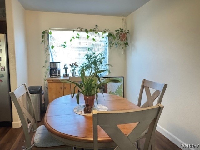 dining area with baseboards and dark wood-type flooring