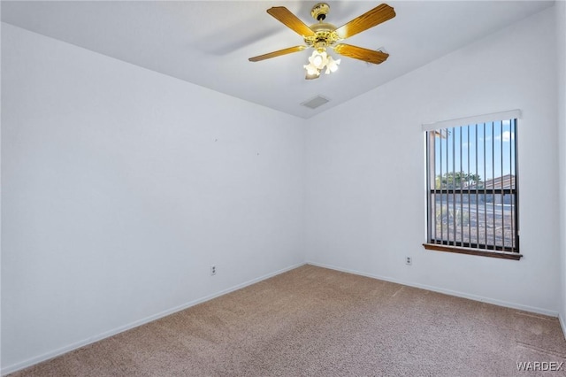 spare room with ceiling fan, visible vents, vaulted ceiling, and carpet flooring