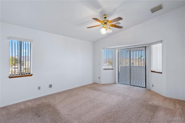 spare room with plenty of natural light, visible vents, and light colored carpet