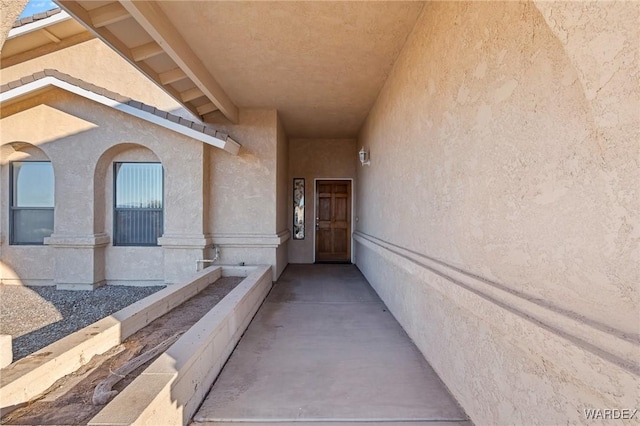 entrance to property featuring a tile roof and stucco siding