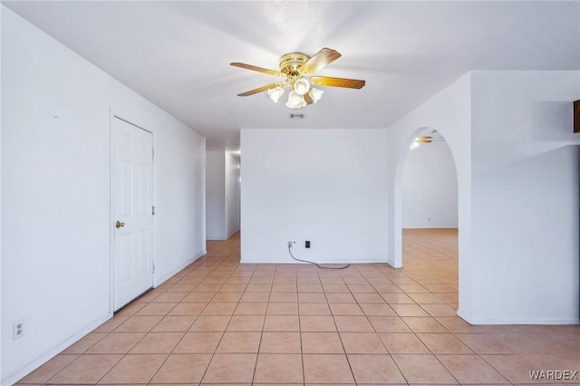 unfurnished room featuring ceiling fan, light tile patterned floors, arched walkways, and visible vents