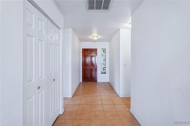 corridor featuring visible vents and light tile patterned floors