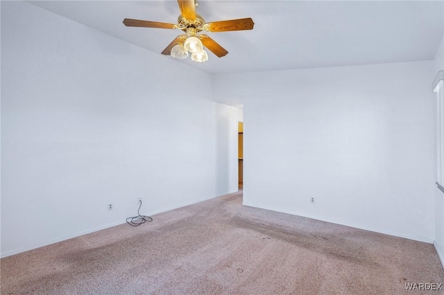 spare room with a ceiling fan and light colored carpet