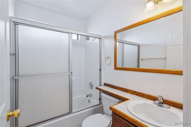 full bath with enclosed tub / shower combo, vanity, and toilet