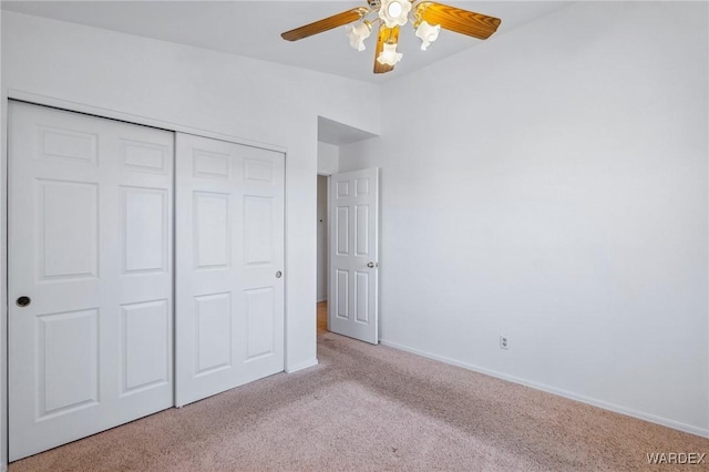 unfurnished bedroom with light carpet, baseboards, a closet, and lofted ceiling